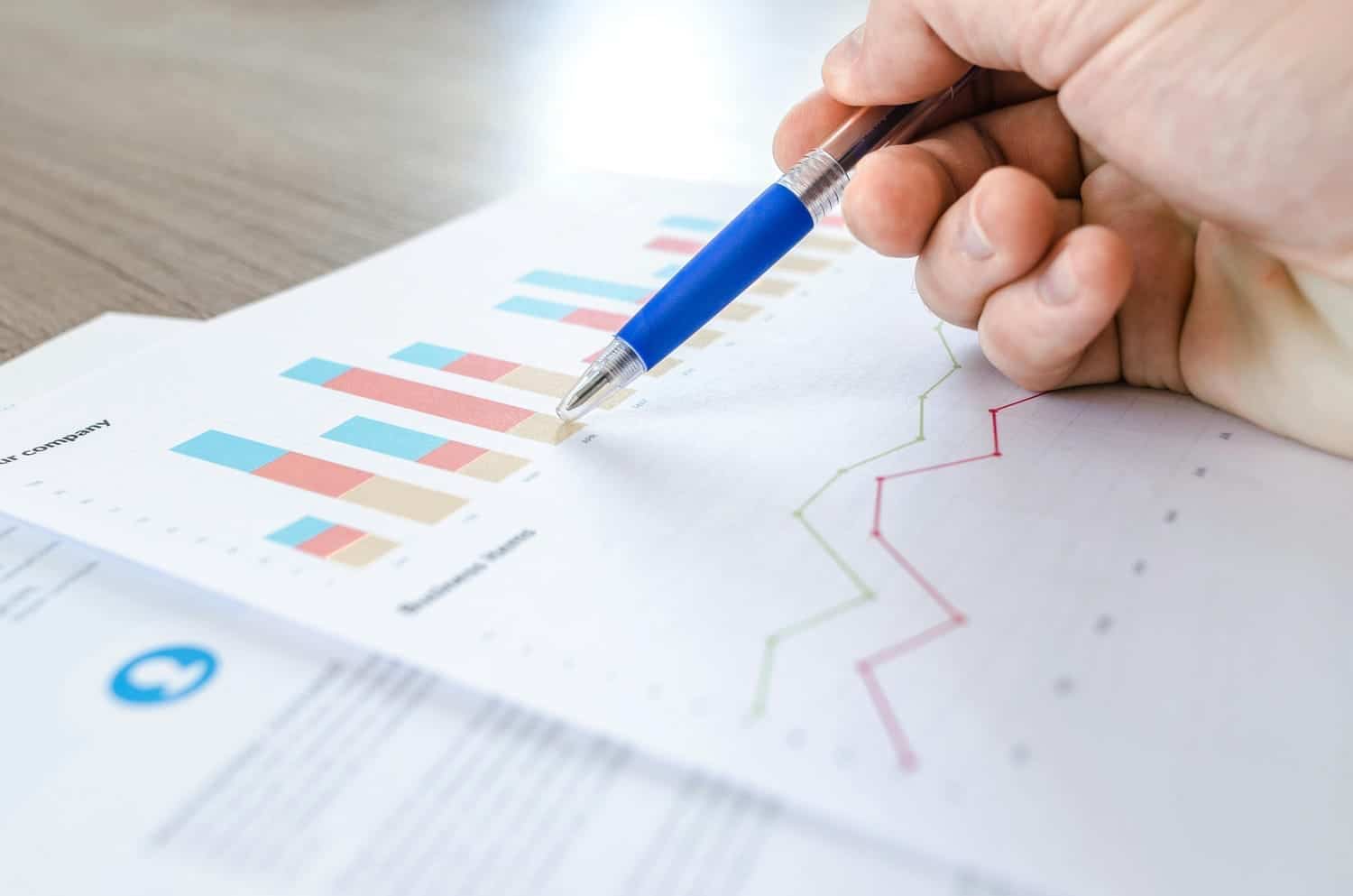 Une main pointe un graphique statistique sur un document.