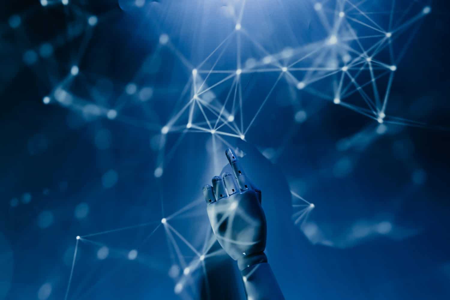 Une main robotique touche un réseau de points lumineux sur fond bleu.