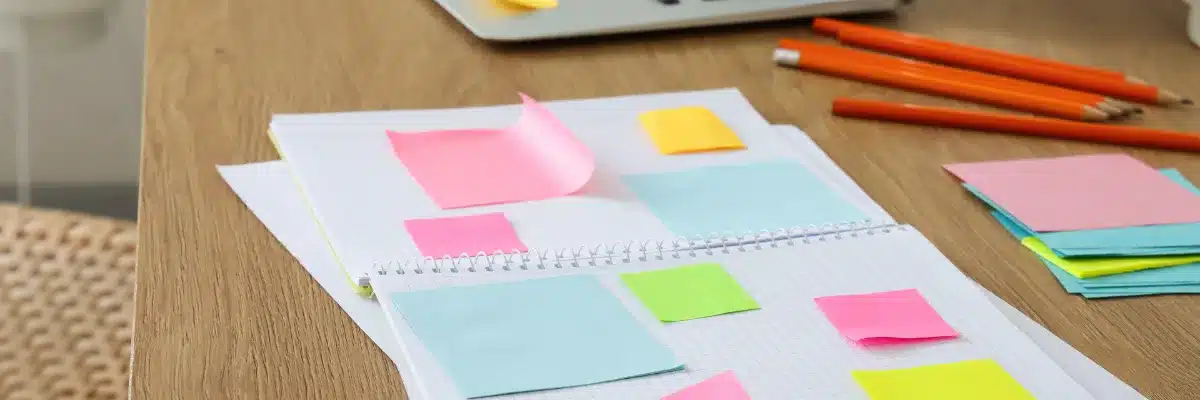 Des notes et des post-it sur un carnet, pour lister les mots des clients