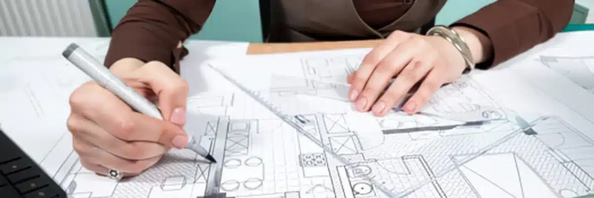 Une personne dessine un plan sur une grande feuille avant de passer à la réalisation